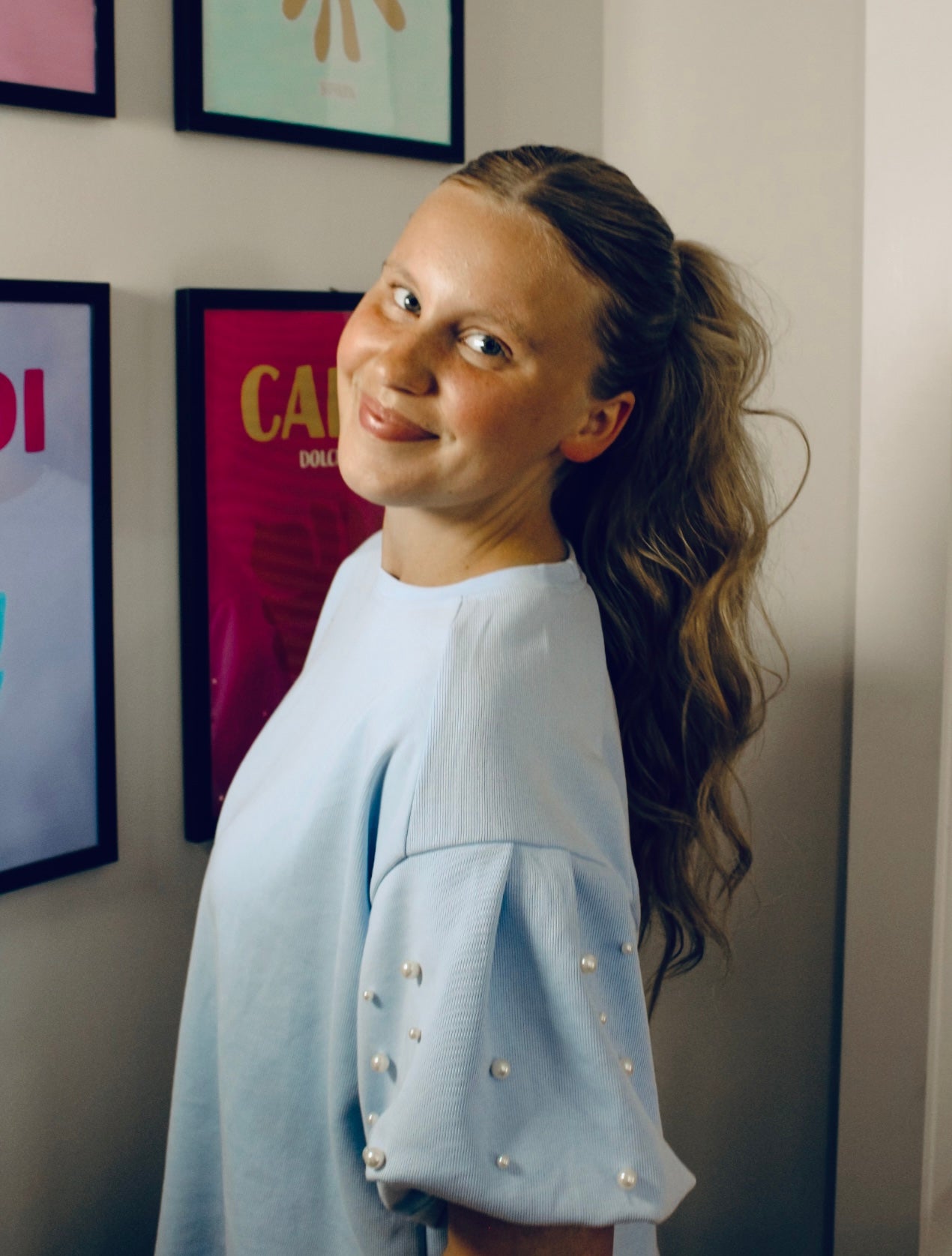 Darling in pearls in light blue knit top.