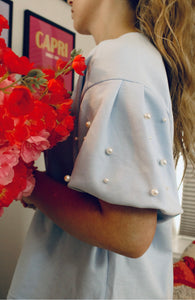 Darling in pearls in light blue knit top.