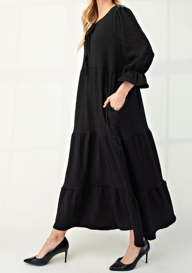 Side View of Black Color - Tiered Maxi Dress with 3/4 Length Puff Sleeves and Ruffled Cuffs, Round Neckline with Keyhole Cutout and Detail Tying Bow