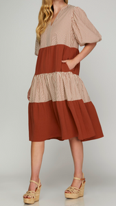 Regular Size - Front/Side View of Rust Color - Midi Length Dress with 1/2 Puff Sleeves, Tiered Style, Alternating Rust/Cream Striping and Solid Rust Tiers