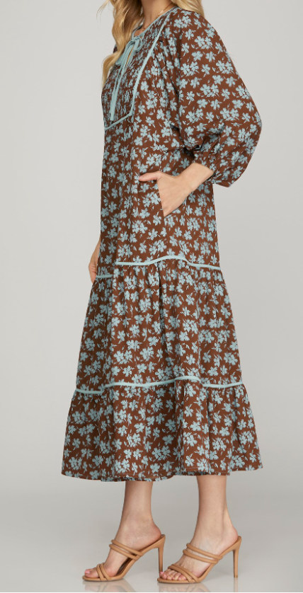 Side View of Brown Color - Midi Length, 3/4 Length Sleeves with Elastic Cuffs, Tiered Style, Brown with Soft Blue Floral Detail, Round Neckline with Keyhole Detail Opening with Tieable Tie