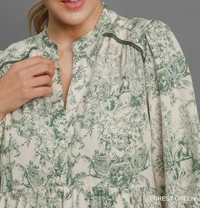 Detail View of Forest Green Color - Christmas Landscape Dress - Midi Length - Long Balloon Sleeves with Elastic Cuffs - V-Neck Neckline - Landscape Pattern - Embroider Details Around Top of Bodice and Around Lower Portion of Skirt